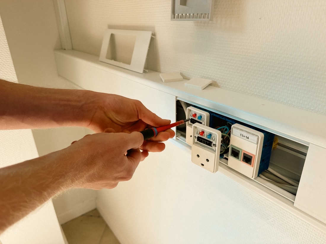 Elektriker fra Hørlykke EL skruer stikkontakt og dataudtag fast i væggen