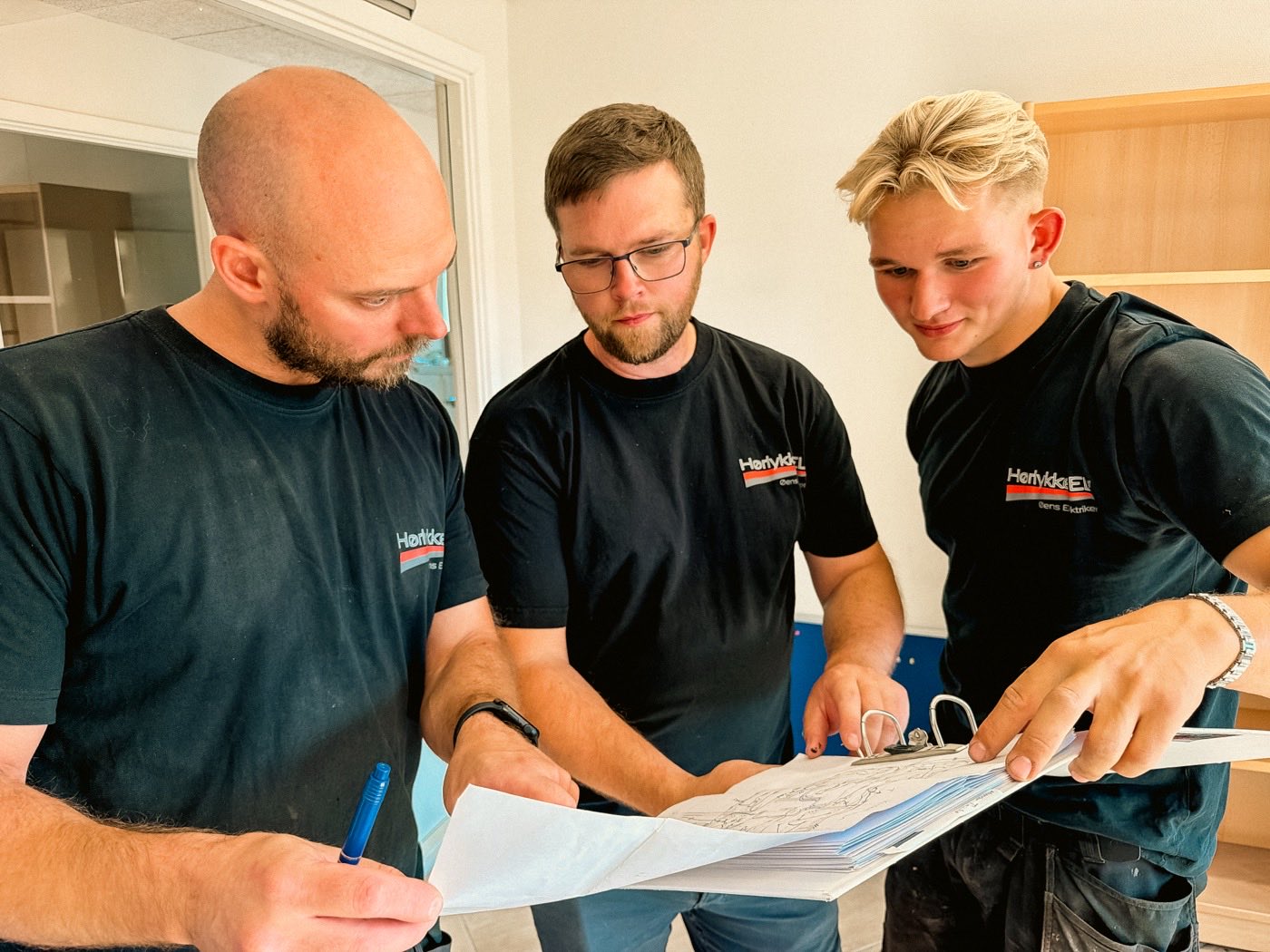 lokal-a-kolleger Tre elektrikere fra Hørlykke EL gennemgår en tegning sammen
