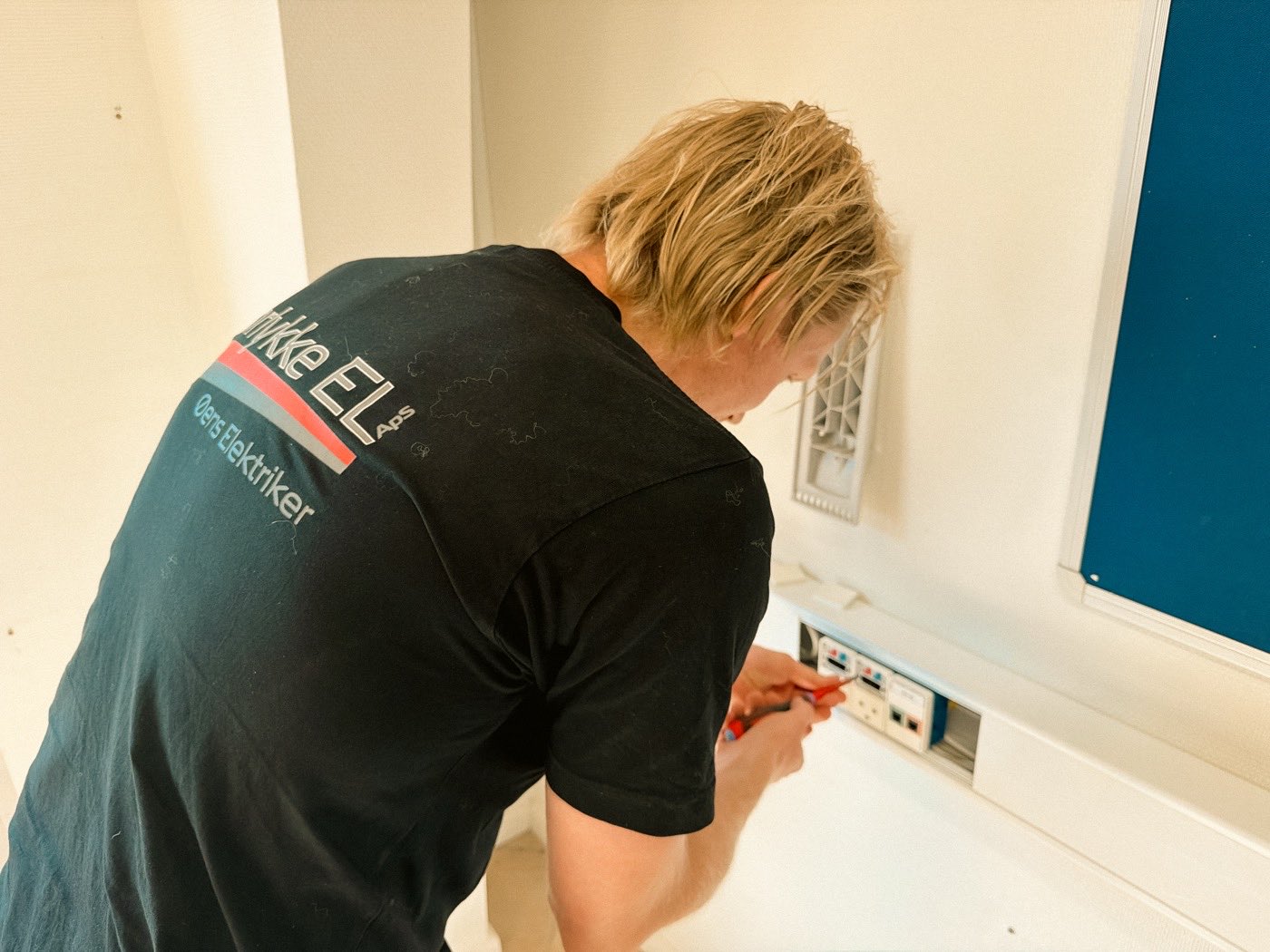 lokal-a-udtag Elektriker fra Hørlykke EL monterer et udtag i væggen på et kontor