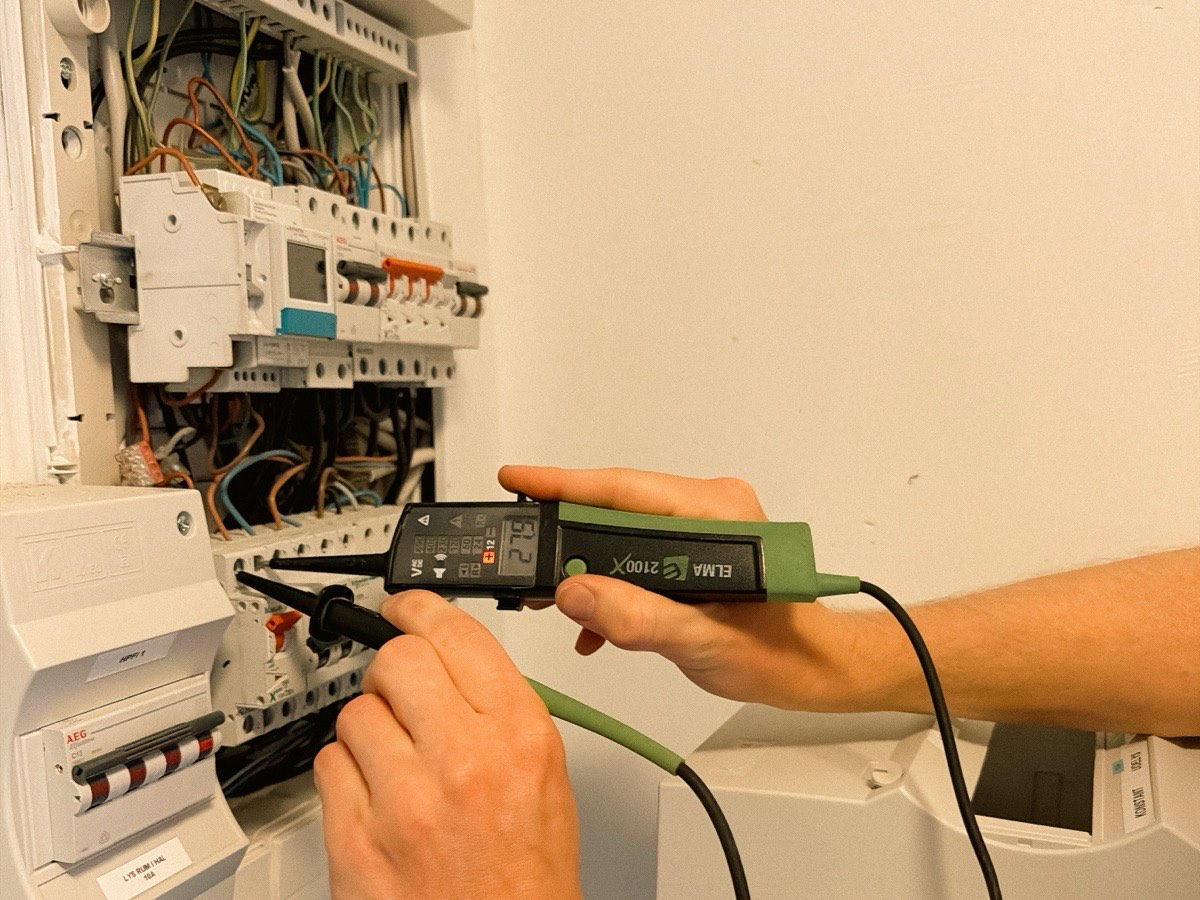 Elektriker fra Hørlykke EL måler i en eltavle med en spændingstester